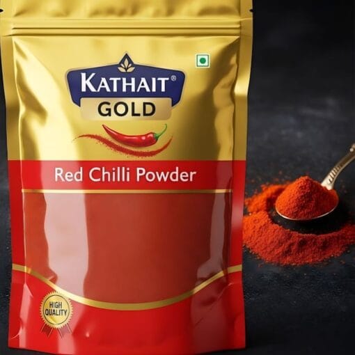 Kathait Gold Red Chilli Powder In Its Golden And Red Pouch, With A Spoonful Of The Vibrant Red Spice Powder On The Side.