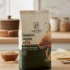 Premium Hilvera Chakki Fresh Atta packaging with 100% natural and preservative-free whole wheat flour, showing soft rotis and wheat stalks on a rustic wooden table.