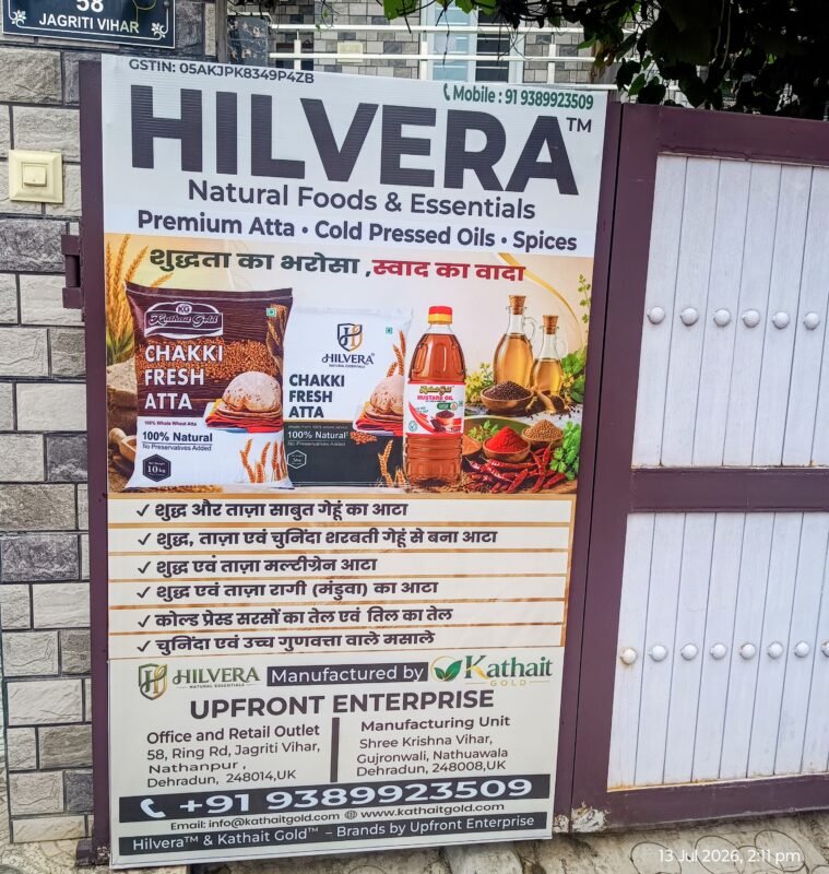 Upfront Enterprise – Dehradun's Local Hub for Wholesale & Retail Food Products 1 Hilvera Natural Foods &Amp; Essentials Signboard At Upfront Enterprise Office In Jagriti Vihar, Dehradun Featuring Chakki Fresh Atta, Cold Pressed Mustard Oil, Spices, And Kathait Gold Branding